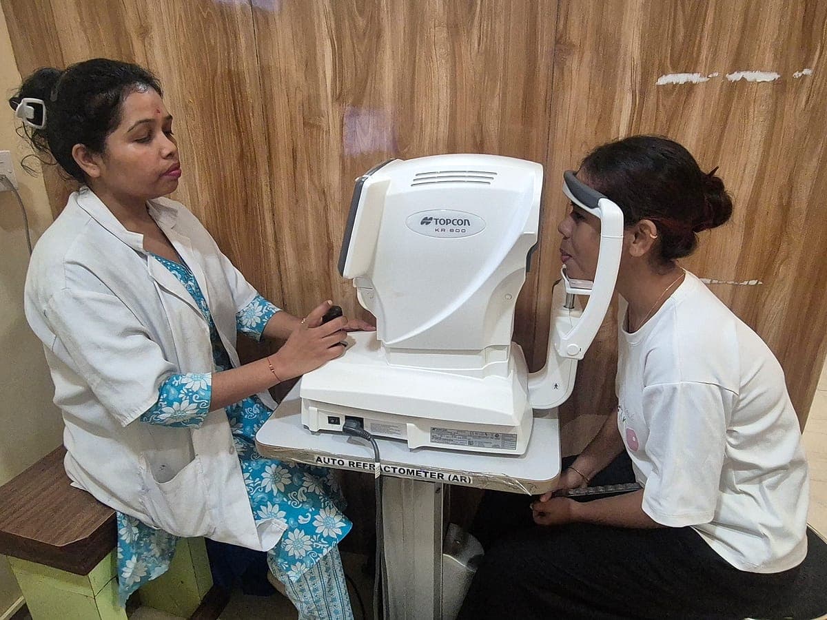 Optometrist checking glasses power on a Topcon auto-refractometer at Ruby Eye Hospital